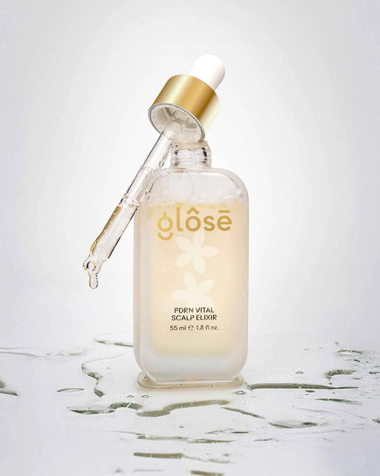 Glôsē PDRN Vital Scalp Elixir bottle with lifted dropper applicator and liquid splash